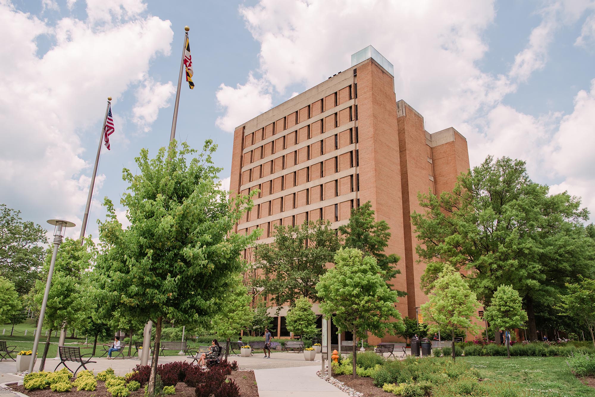 UMBC's Administration building, viewed from below. Maryland and USA flags beside it.