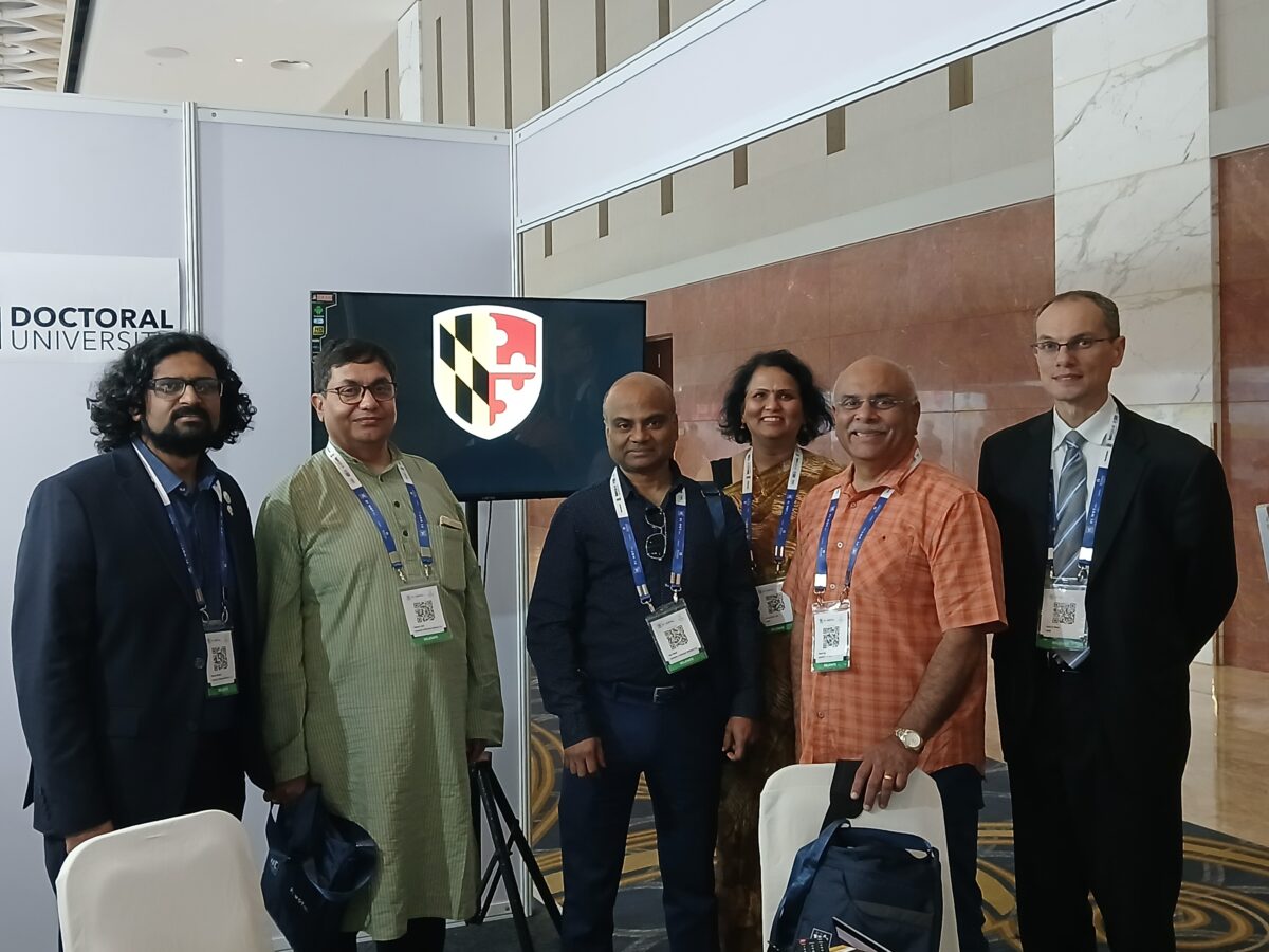 Group of six people at conference booth.